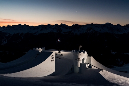 Snowboarderin die über eine Schneeburg springt